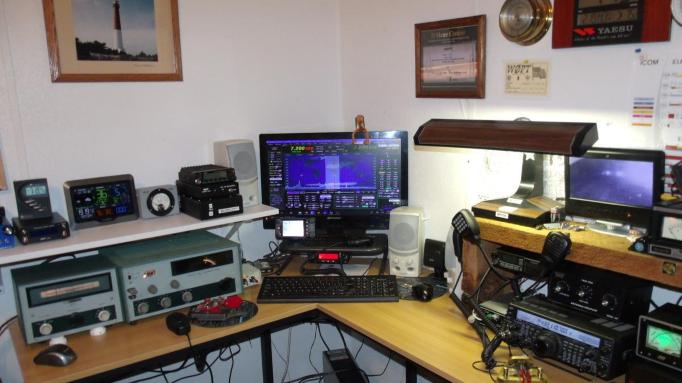 Photo of a home ham radio set-up including a computer and a lot of electronics equipment